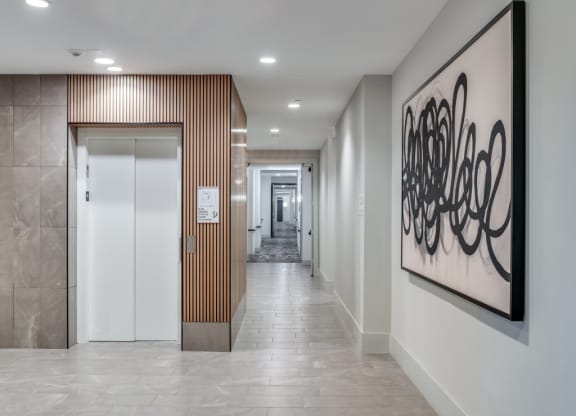 a hallway with a painting on the wall and a door