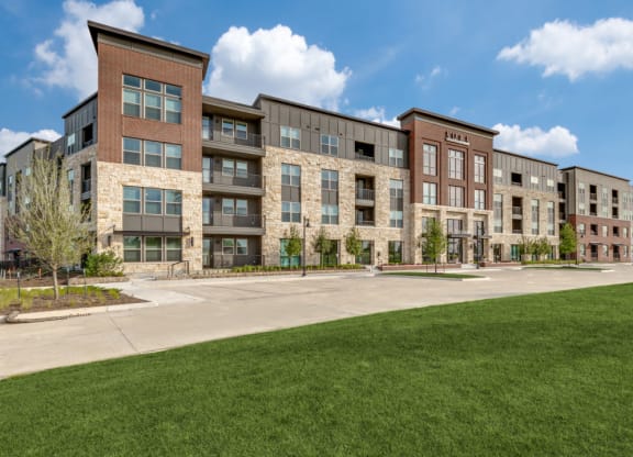 an exterior view of an apartment building on a sunny day