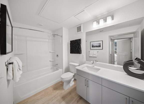 A white bathroom with a toilet, sink, and bathtub.