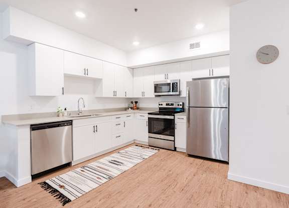A modern kitchen with stainless steel appliances and white cabinets.