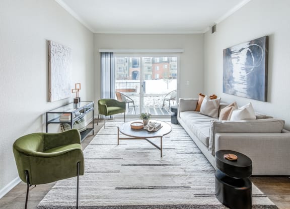 a living room with white walls and a large sliding glass door that leads to a balcony