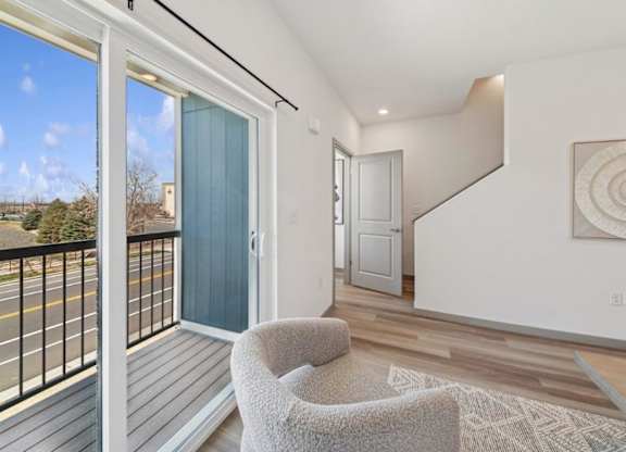 A balcony with a chair and a view of the street.