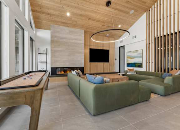 A modern living room with a pool table and a fireplace.