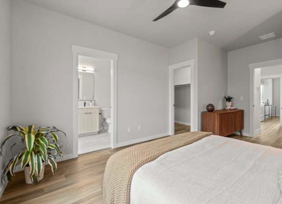 A bedroom with a large bed and a ceiling fan.