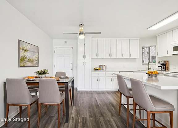 A kitchen with a dining table and chairs.