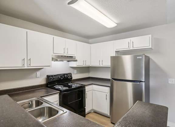 A kitchen with a stove, oven, and refrigerator.