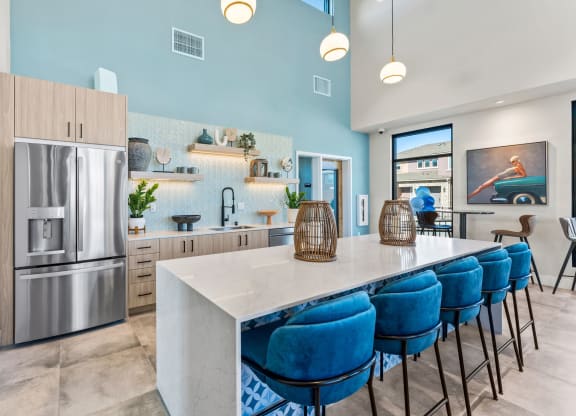 Marlette open kitchen with stainless steel appliances and blue chairs