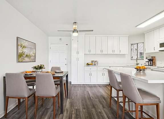 A kitchen with a dining table and chairs.