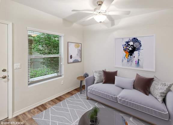 A living room with a grey couch and a painting on the wall.