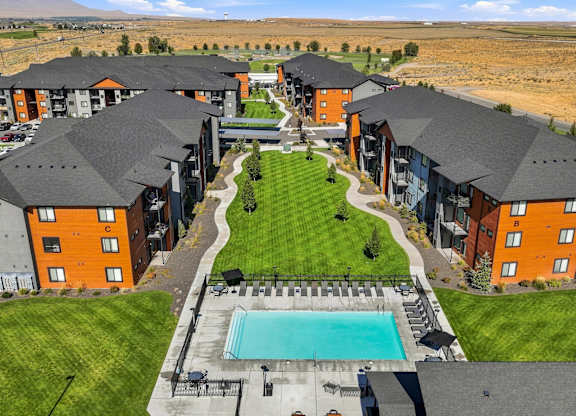 A large apartment complex with a swimming pool in the middle.