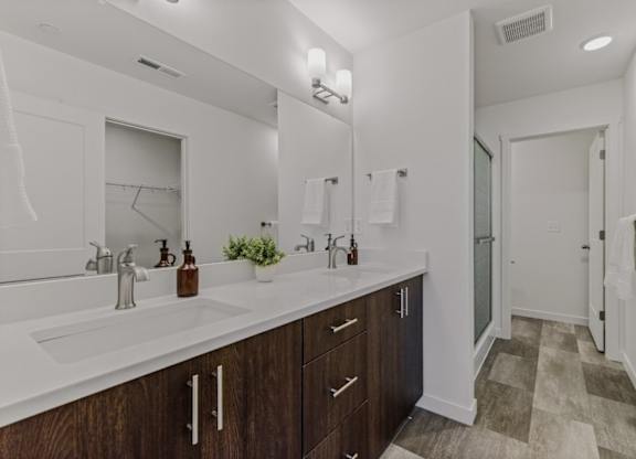 A bathroom with a white counter top and a mirror above it.