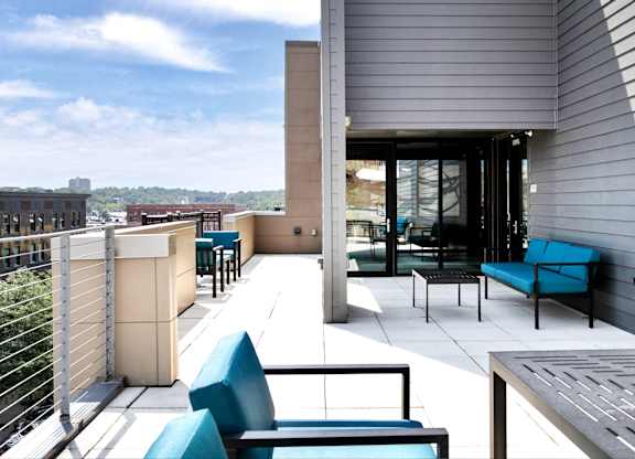 A patio with blue chairs and a table.