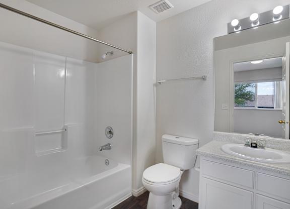 A white bathroom with a toilet, sink, and bathtub.