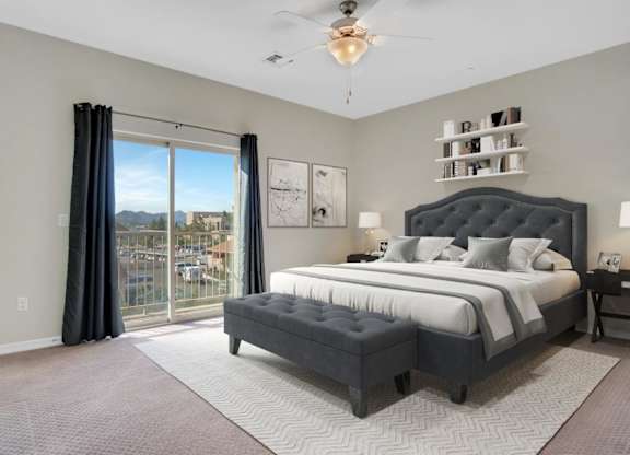A bedroom with a large bed and a view of the city.