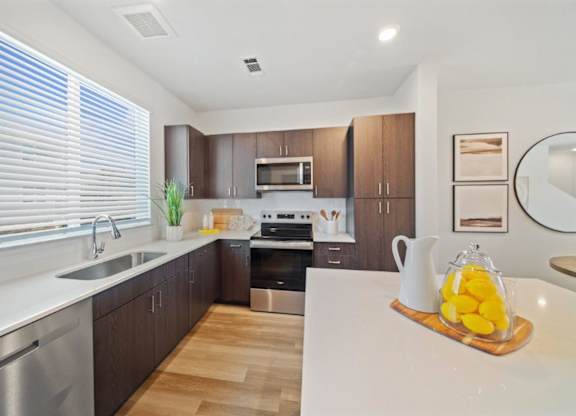 A modern kitchen with wooden cabinets and stainless steel appliances.