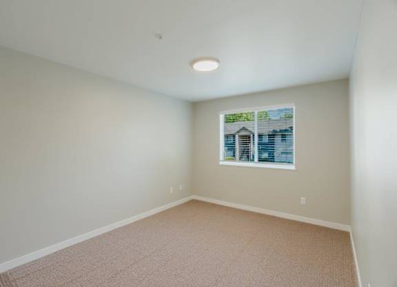 Empty room with carpeted floor and a picture on the wall.