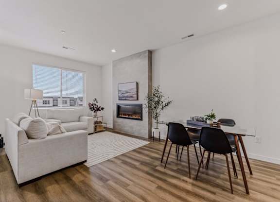 A living room with a white couch, a coffee table, and a fireplace.