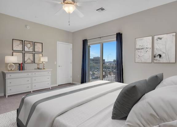 A bedroom with a large bed and a view of the city.