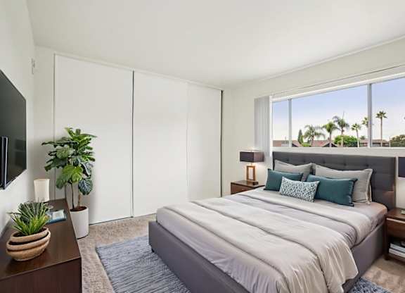 A bedroom with a large bed and a flat screen TV.