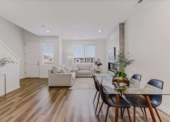A modern living room with a glass dining table and chairs.