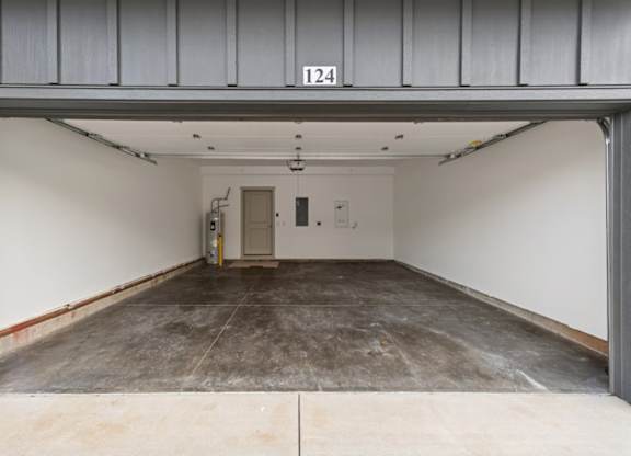 A large, empty garage with a concrete floor and a door at the end.