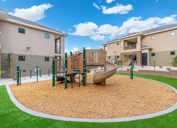 a playground with a slide in the middle of an apartment complex