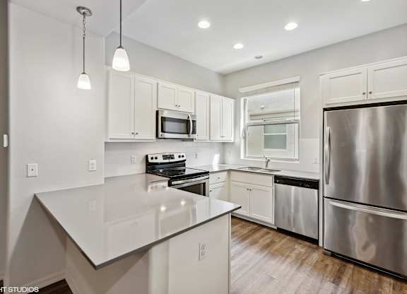 A modern kitchen with stainless steel appliances and white cabinets.