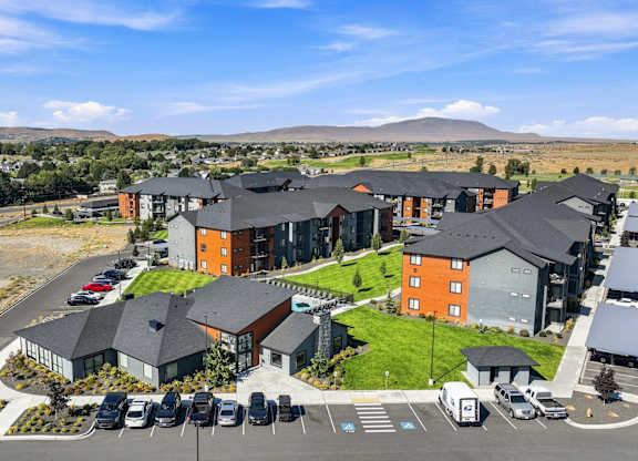 A large building complex with a parking lot in front.