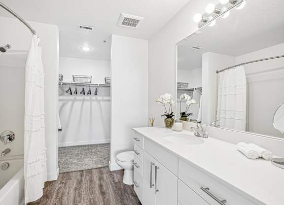 A white bathroom with a white tub, sink, and toilet.