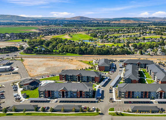 A bird's eye view of a residential area with multiple houses and a parking lot.