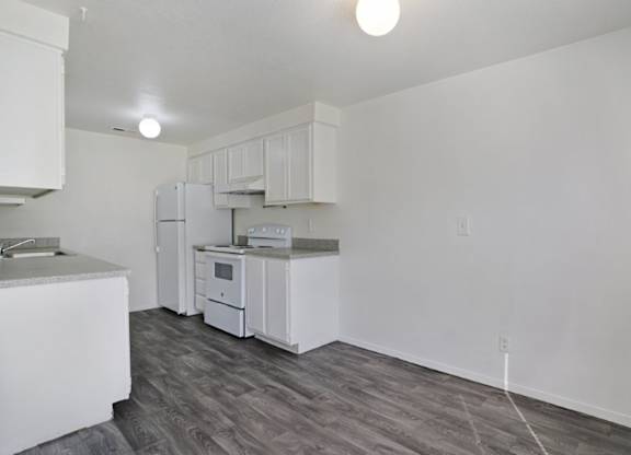 A kitchen with white appliances and cabinets.