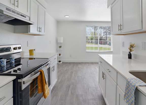 A kitchen with white cabinets and a black stove top.