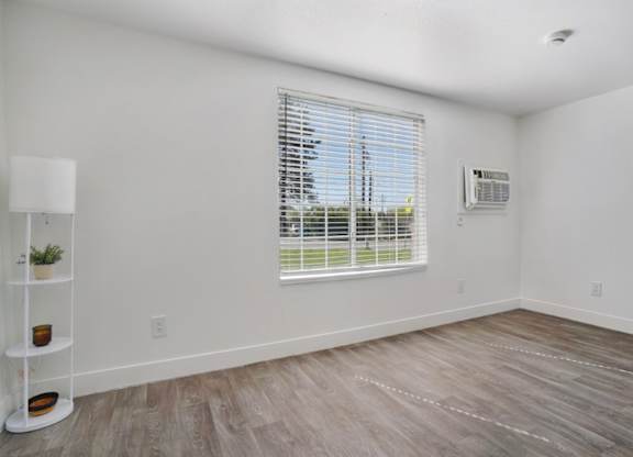 A room with a window and a floor lamp.