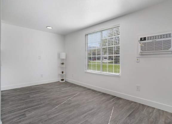 A room with a window and a wall-mounted air conditioner unit.