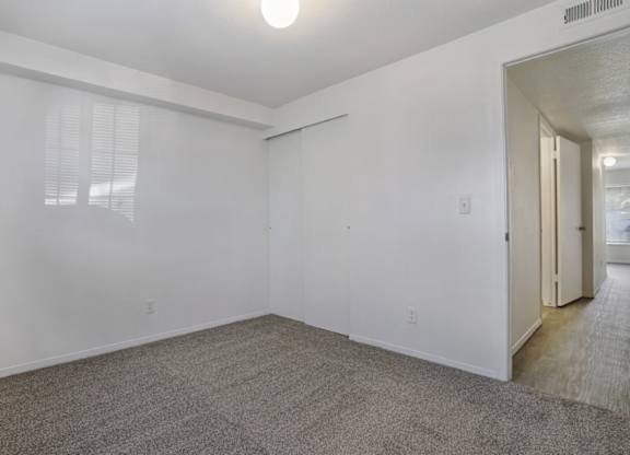 A room with white walls and carpeted floor.