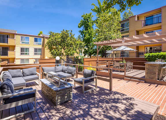A sunny day at a wooden deck with a table and chairs.
