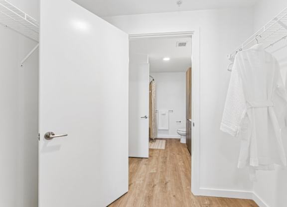 A white bathroom with a towel hanging on the rack.