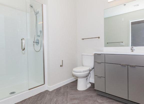 A white toilet sits in a bathroom next to a walk-in shower.