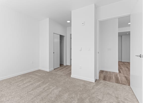 a living room with white walls and a carpeted floor
