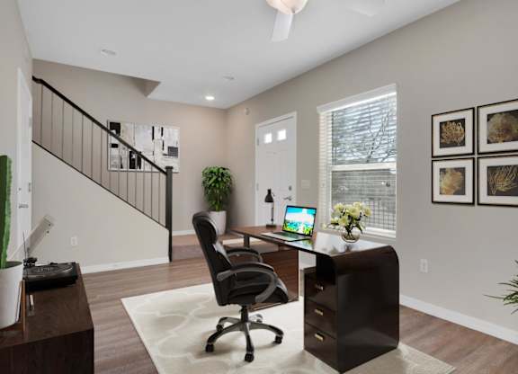 A home office with a desk, chair, and a laptop.