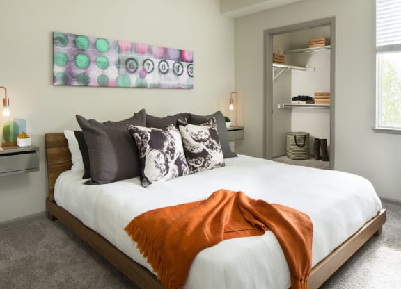 a bedroom with white bedding and an orange blanket