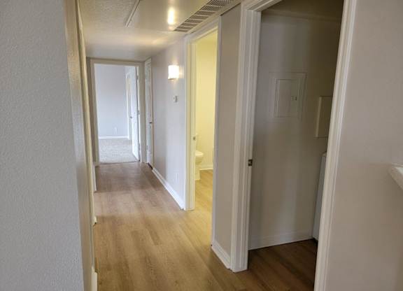 a passageway between two bedrooms and a hallway with a door to a bathroom