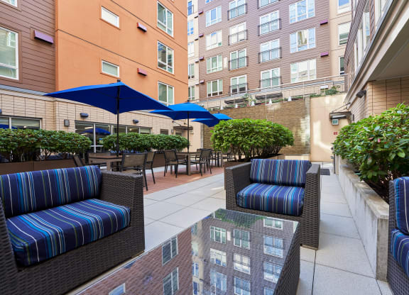 a patio with chairs and tables and umbrellas