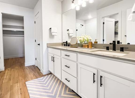 A bathroom with a striped rug on the floor.