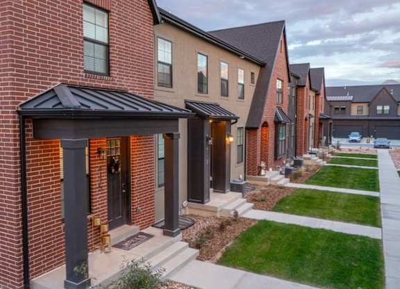 A row of houses with a red brick house in the front.