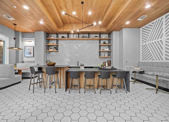 A modern kitchen with a wooden ceiling and hexagonal tiles on the floor.