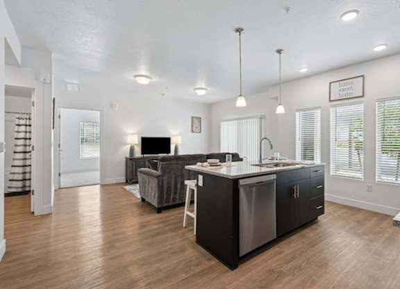 A modern kitchen with a wooden floor and a large island.