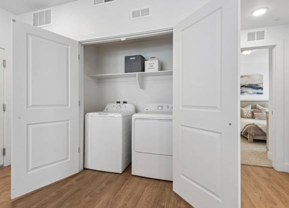 A white laundry room with a washer and dryer.