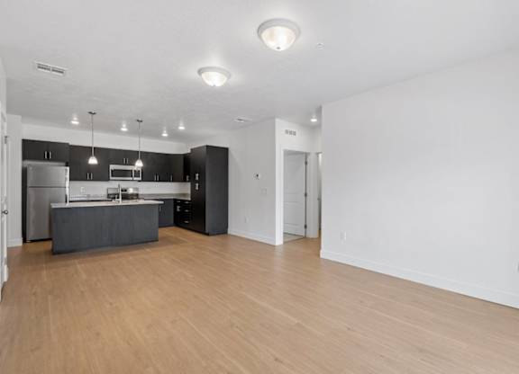 A kitchen with a refrigerator, oven, and sink.
