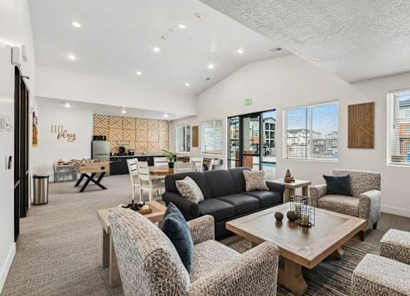 A spacious living room with a variety of seating options and a view of the outside through the windows.